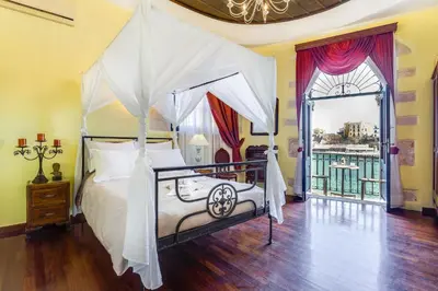 a bedroom with a canopy bed and a window at Casa Leone Hotel in Chania Town