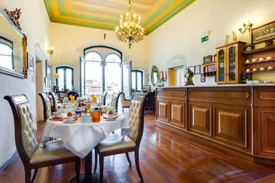 a dining room with a table and chairs and a chandelier at Casa Leone Hotel in Chania Town