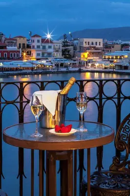a table with a bottle of wine and two glasses at Casa Leone Hotel in Chania Town