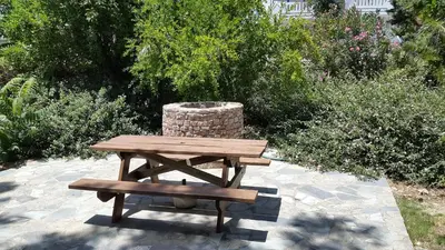 a wooden picnic table and bench in a garden at Stelios Rooms in Palaiochóra