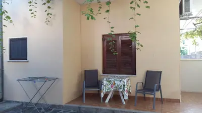 two chairs and a table and a window at Stelios Rooms in Palaiochóra