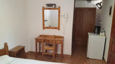 a room with a table and a chair and a mirror at Stelios Rooms in Palaiochóra