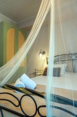 a bedroom with a bed with a mosquito net at Santa Elena Boutique Rooms in Chania Town