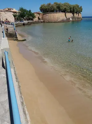 a beach with people swimming in the water at Brigitte house in Chania Town