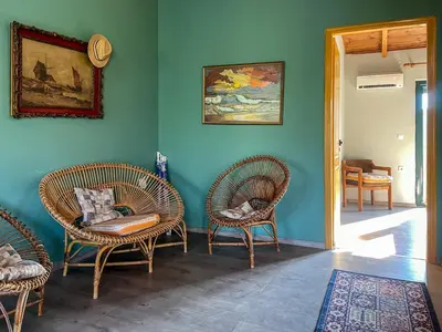 a living room with chairs and a blue wall at Kavros House in Arménoi
