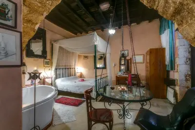 a bathroom with a tub and a bedroom with a bed at Ifigenia Traditional Rooms & Maisonettes in Chania Town