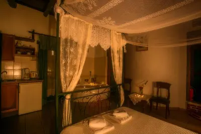 a bedroom with a canopy bed and a kitchen at Ifigenia Traditional Rooms & Maisonettes in Chania Town