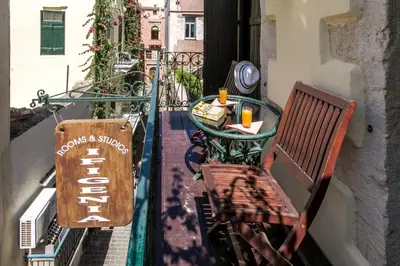 a balcony with a table and a bench and a sign at Ifigenia by Captain Michalis in Chania Town