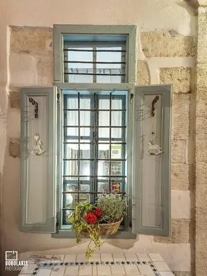 a window with a basket of flowers in front of it at Pension Lena in Chania Town