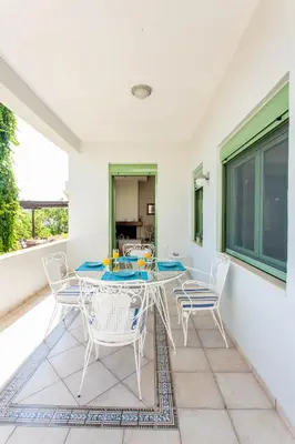 a dining room with a table and chairs on a balcony at Chania Sea View Summer House in Kalamaki Chanion