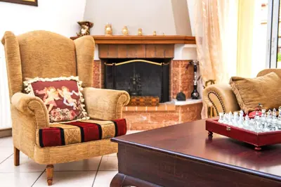 a living room with two chairs and a fireplace at Marelen Apartment Near Chania Center in Chania Town