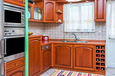 a kitchen with wooden cabinets and a sink at Marelen Apartment Near Chania Center in Chania Town