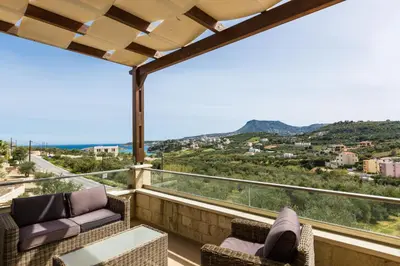 a balcony with chairs and a view of the mountains at Levanda Luxury Stone Villa in Kalyves