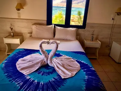 a bedroom with a bed with a heart shaped towel at Flisvos Rooms in Frangokastello