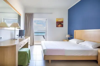 a hotel room with a bed and a desk and a window at Elena Beach Hotel in Kissamos