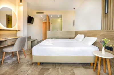 a bedroom with a bed and a table and a chair at Elena Beach Hotel in Kissamos