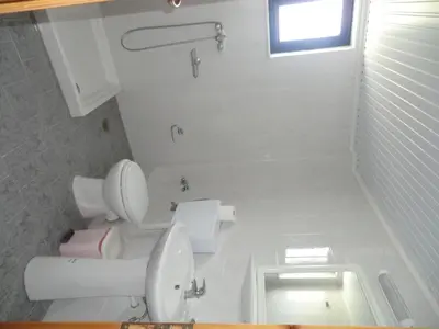 a white bathroom with a toilet and a sink at Flisvos Apartments in Frangokastello