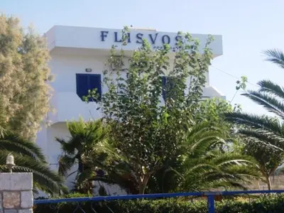 a white building with a blue sign on it at Flisvos Apartments in Frangokastello