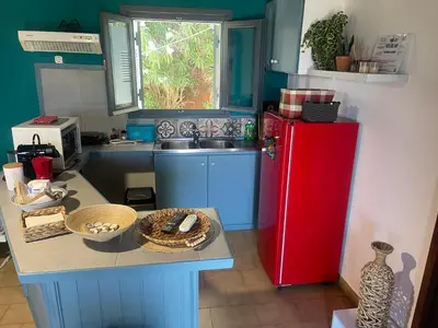a kitchen with a red refrigerator and a sink at Villas Vista Del Mar in Kissamos