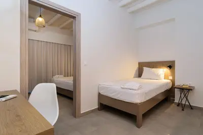 a bedroom with a bed and a table and a mirror at Kyma in Loutro
