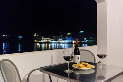 a table with two glasses of wine and a plate of food at Kyma in Loutro