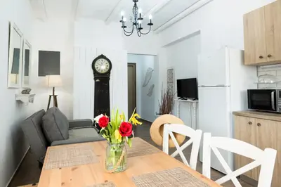 a dining room and living room with a table and a clock at EvaEle Luxury Boutique in Kissamos