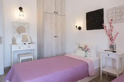 a bedroom with a pink bed and white cabinets at EvaEle Luxury Boutique in Kissamos