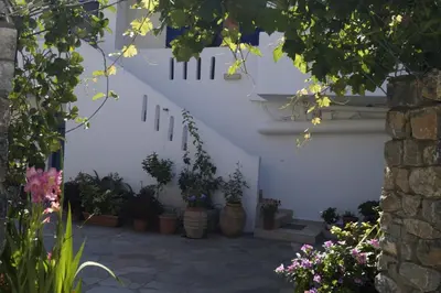 a courtyard with potted plants and stairs in a building at Paralia guest house in Agia Roumeli