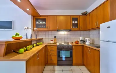 a kitchen with wooden cabinets and a stove top oven at Agrimia Holiday Apartments in Plataniás