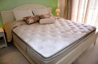aquarteredquarteredquartered bed with a white mattress and a window at Agrimia Holiday Apartments in Plataniás