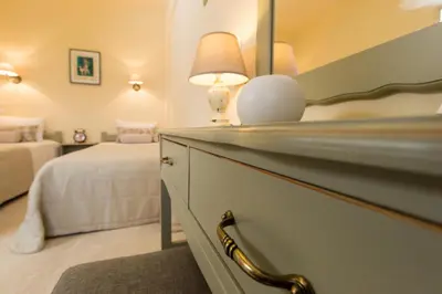 a bedroom with a bed and a desk with a lamp at Agrimia Holiday Apartments in Plataniás