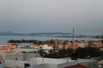 a view of a city with buildings and a body of water at Mithos Premium Rooms in Agia Marina Nea Kydonias