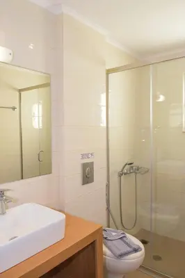a bathroom with a shower and a sink and a toilet at Mithos Premium Rooms in Agia Marina Nea Kydonias