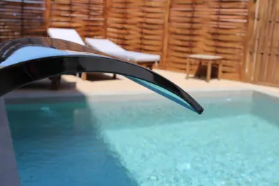 a swimming pool with aaucet in a room at Mithos Premium Rooms in Agia Marina Nea Kydonias
