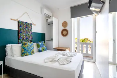 a bedroom with a large white bed and a window at Kumba At Koum Kapi in Chania Town