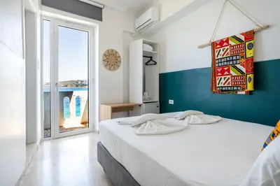 a bedroom with a bed and a large window at Kumba At Koum Kapi in Chania Town