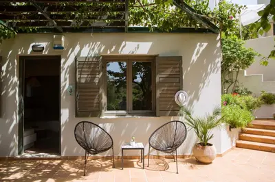 two chairs and a table in front of a house at Villa Pefki in Chania Town