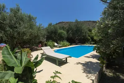 a swimming pool with a chaise lounge and a chair at Sofiana's Garden Retreat with Private Pool in Drapaniás