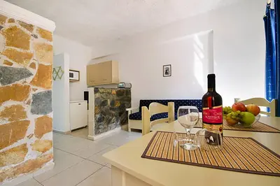 a bottle of wine sitting on a table with two glasses at Stavros Villas&Apartments in Gerani Chanion