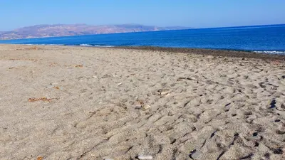 a sandy beach with footprints in the sand next to the ocean at Stavros Villas&Apartments in Gerani Chanion