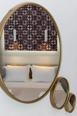 a mirror over a bed with white pillows in a room at NK Apartments in Falasarna