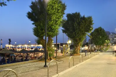a street with trees and tables and umbrellas at Aristea's Apartment 1st Floor in Chania Town