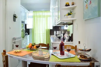 a kitchen with a table with two glasses of wine at Aristea's Apartment 1st Floor in Chania Town