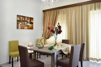 a dining room table with chairs and a vase of flowers at Aristea's Apartment 1st Floor in Chania Town