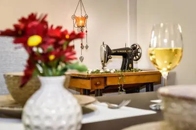 a table with a vase of flowers and a glass of wine at Casa Veneziana in Chania Town