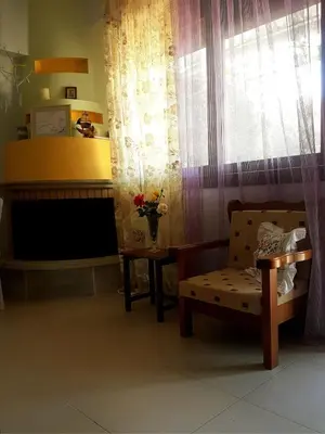 a living room with a chair and a window at Elia Guesthouse - Kissamos in Kissamos