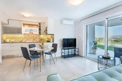 a kitchen and living room with a table and chairs at Villa Oasis in Galatás