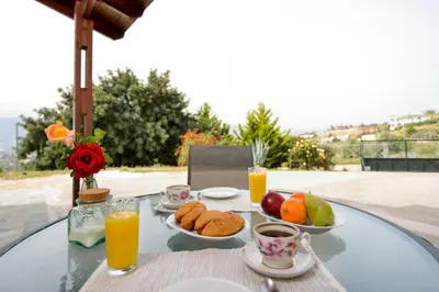 a table with plates of food and orange juice at Feels like home in Chania Town