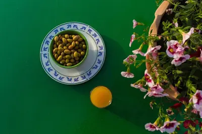 a bowl of chickpeas on a green table with flowers at Villa Stefania - with Sea View Terrace in Drapaniás