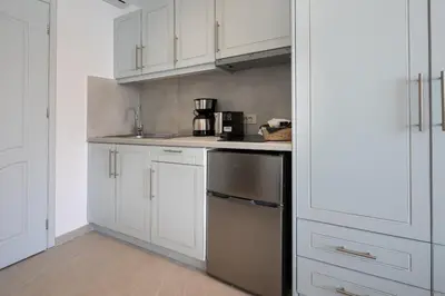 a kitchen with white cabinets and a counter top at Molos Apartments in Loutro